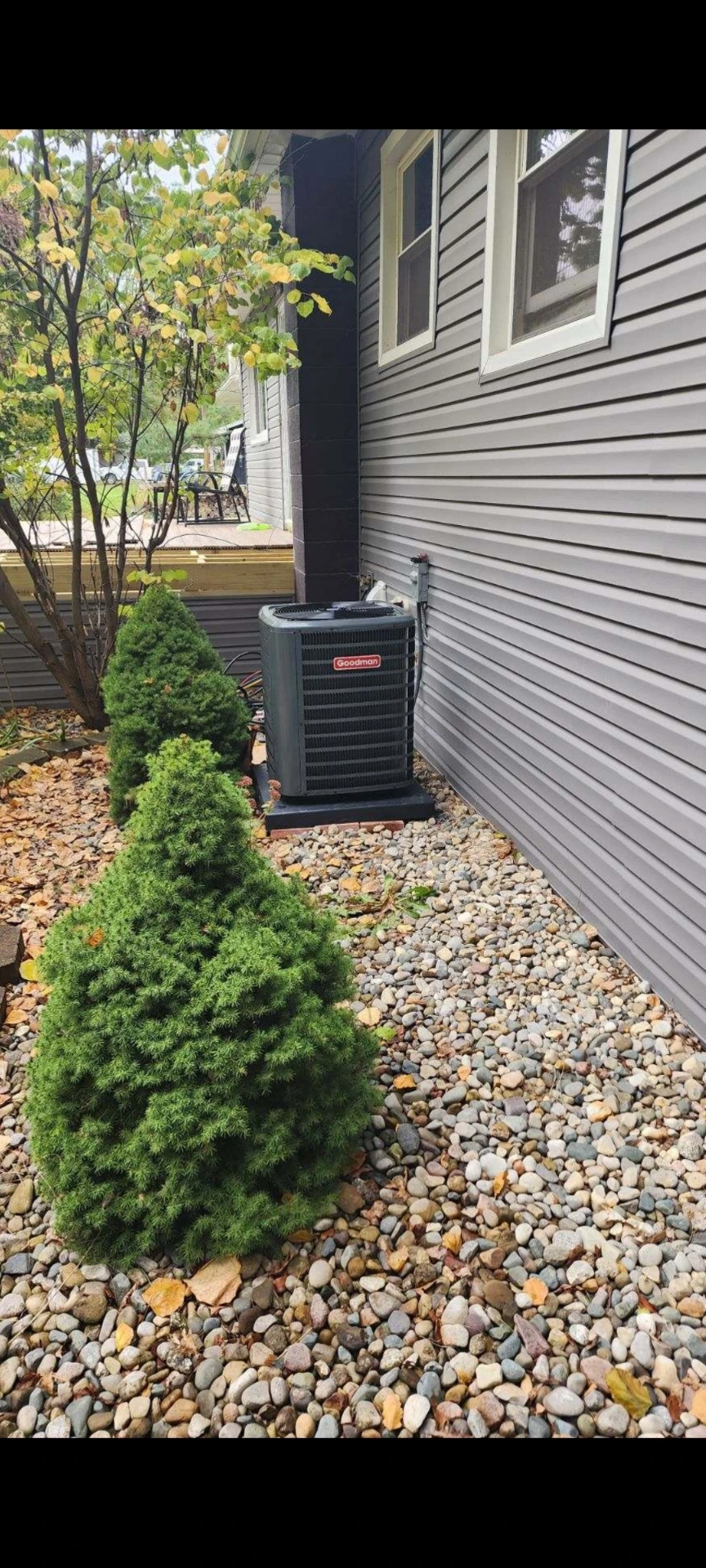 Goodman central air conditioning unit installed next to a Howell, MI home